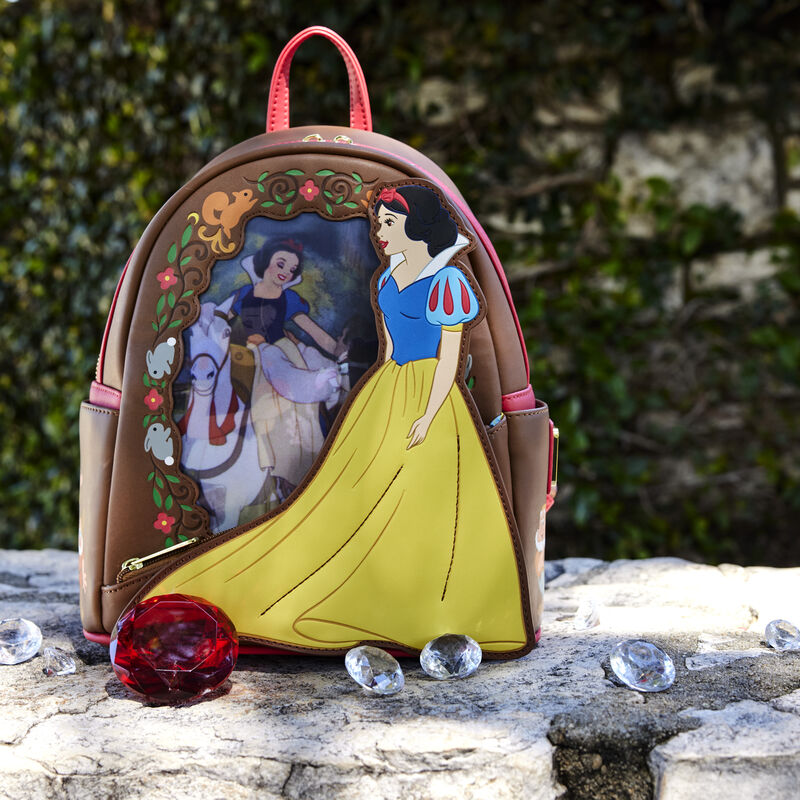 Image of the Snow White Lenticular Mini Backpack outside on a stone wall surrounded by some scattered gems